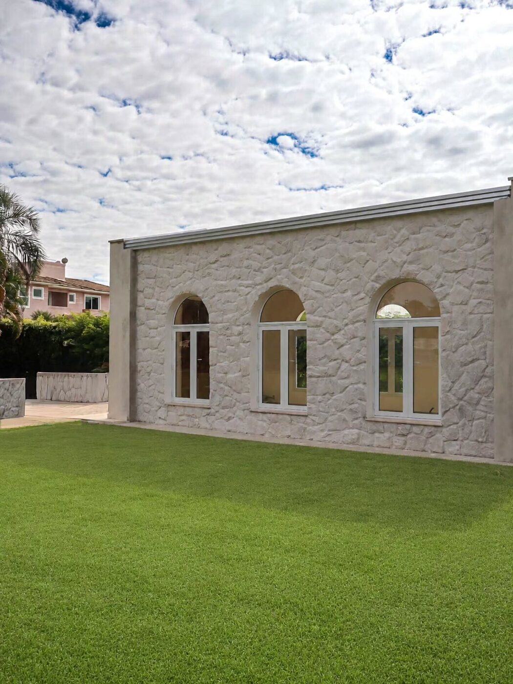 Fachada de estilo clássico com arcos em revestimento de pedra branca